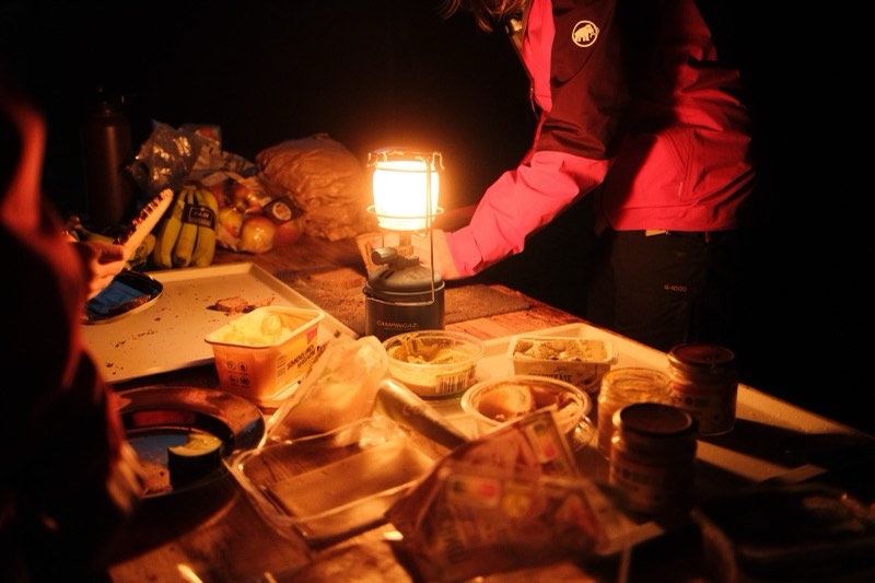 Warm leuchtende Campinglaterne auf einem Tisch bei Nacht