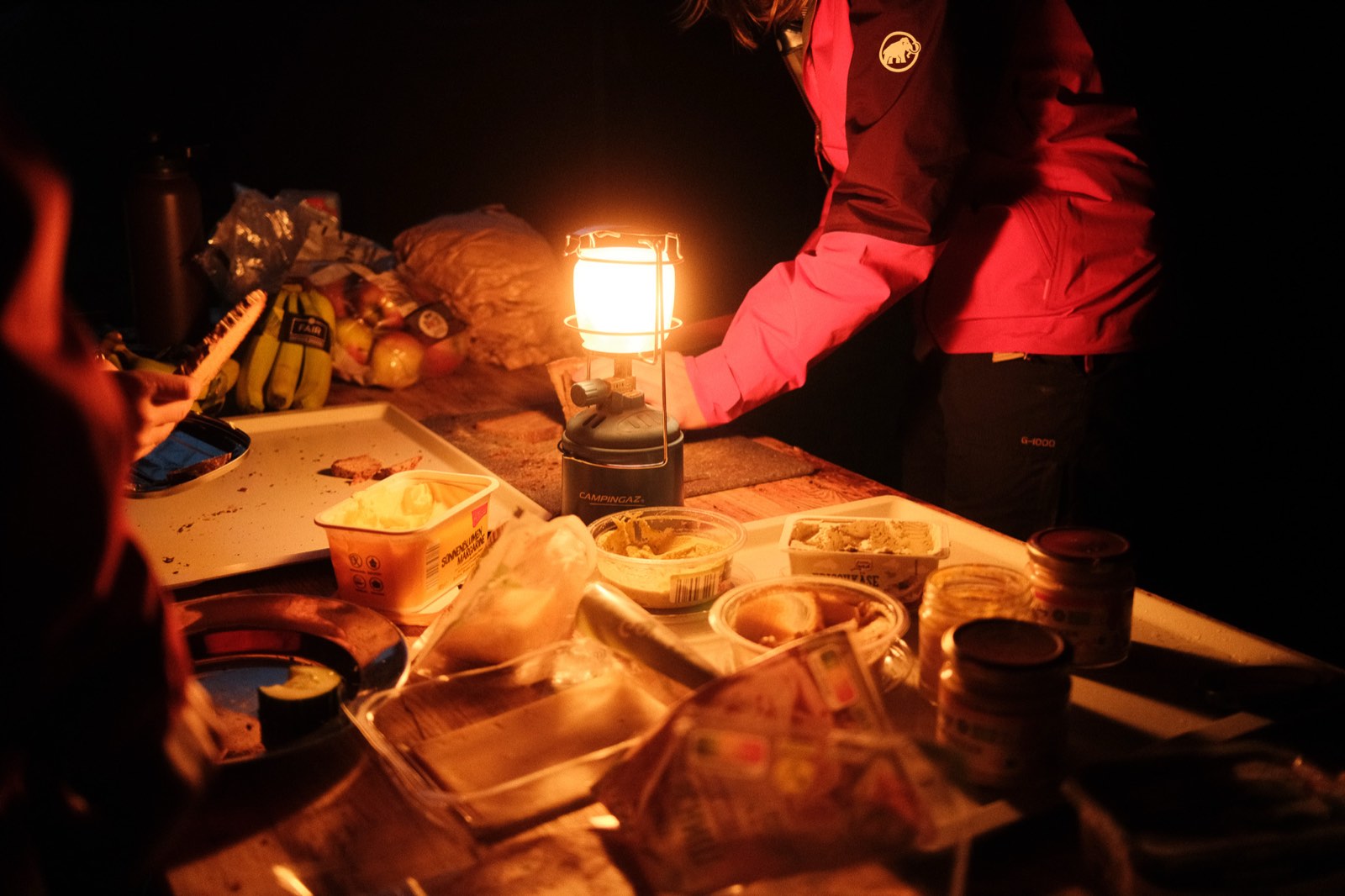 Warm leuchtende Campinglaterne auf einem Tisch bei Nacht
